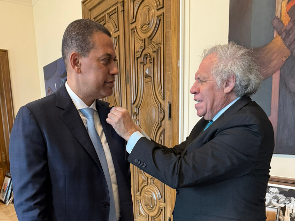 Luis Almagro colocándole pin institucional de la OEA a Guido Gómez Mazara